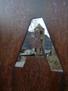 The Romanesque church at Aubinyà glimpsed through a village gate