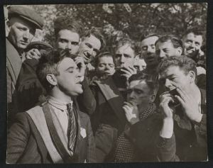 Photograph of J McCauley, a Jarrow marcher, singing to his co-marchers on their walk to London, taken in October 1936 by Edward G Malindine for the Daily Herald. The caption read ''Croonin' J McCauley, who helps to keep his co-marchers' spirits high, has been out of work for 5 years' (National Media Museum)